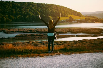 Woman Wearing Black Jacket Standing on Grass Field