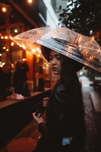 woman wearing black jacket using umbrella