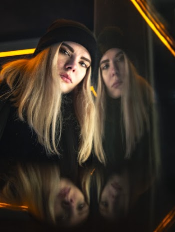 Woman Wearing Black Knit Cap With Glass Wall Reflection