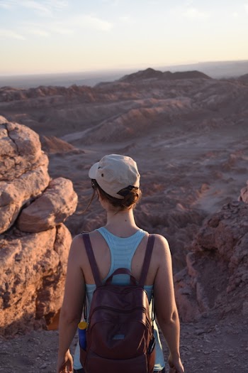 Woman Wearing Black Leather Backpack in Front of Rock
