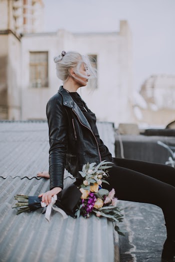 Woman Wearing Black Leather Full-zip Jacket Sitting on Galvanized Roof
