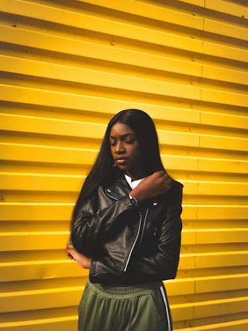 Woman Wearing Black Leather Jacket and Green Track Pants