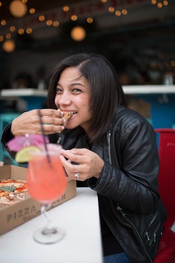 Woman Wearing Black Leather Jacket Eating Pizza