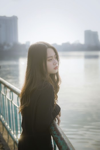 Woman Wearing Black Long-sleeved Shirt Leaning on Green Metal Railing
