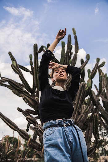 Woman Wearing Black Long-sleeved Shirt Standing Near Cactus