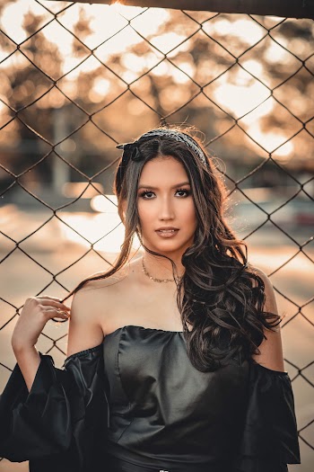 Woman Wearing Black Off-shoulder Top Leaning on Mesh Fence