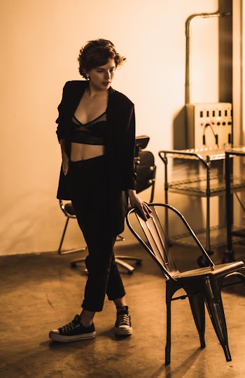 Woman Wearing Black Pants Holding Black Steel Chair