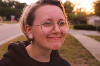 Woman Wearing Black Pullover Hoodie and Round Silver-colored Eyeglasses Smiling