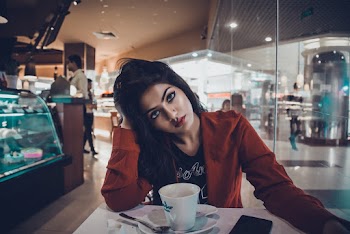 Woman Wearing Black Shirt And Orange Blazer Inside Cafe