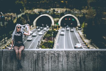 Woman Wearing Black Shirt Sitting Across Highways