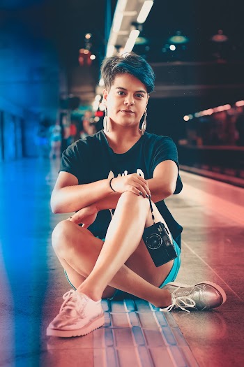 Woman Wearing Black Shirt Sitting on Platform