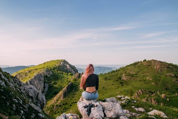 Woman Wearing Black Shirt Sitting on Rock