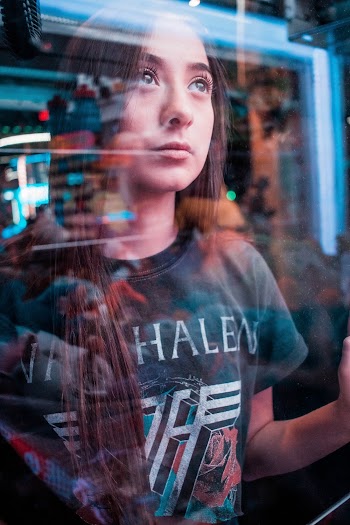 Woman Wearing Black Shirt Standing Beside Clear Glass Wall