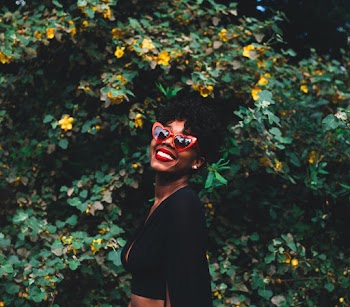 Woman Wearing Black Shirt While Standing Beside Green Plants