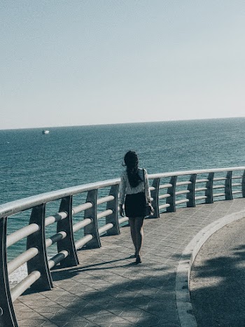 Woman Wearing Black Skirt Standing in Front of Body of Water
