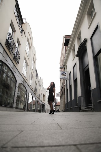 Woman Wearing Black Sleeveless Dress in Between Buildings