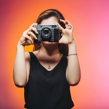 Woman Wearing Black Sleeveless Top Holding Gray Camera