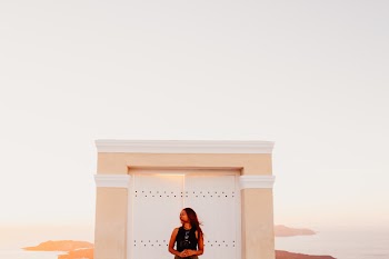 Woman Wearing Black Sleeveless Top Posing in Front of White Wooden Door