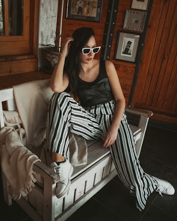 Woman Wearing Black Sleeveless Top Sitting on Sofa