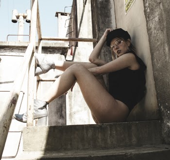 Woman Wearing Black Sleeveless Top Sitting on Stairs