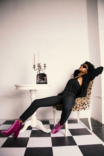 Woman Wearing Black Sleeveless Top While Laying on Brown and Black Floral Chair