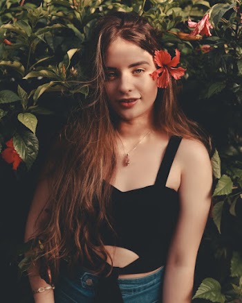 Woman Wearing Black Sleeveless Top With Red Hibiscus in Her Hair