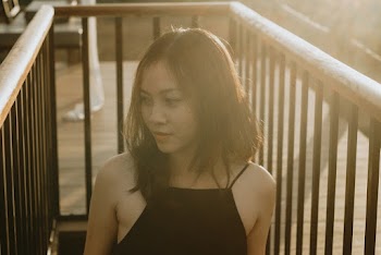 Woman wearing black spaghetti-strap top while walking on stairs