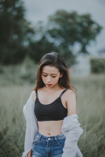 Woman Wearing Black Sports Bra Standing on Green Grass
