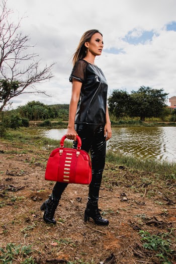 Woman Wearing Black Suit Holding Red Leather Duffel Bag during Day