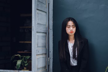 Woman Wearing Black Suit Near Brown Wooden Door