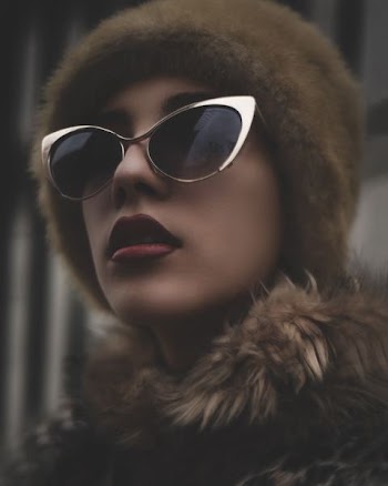woman wearing black sunglasses with gold-colored frames