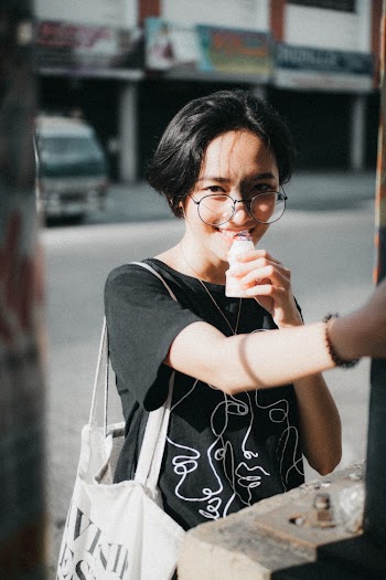 Woman Wearing Black  T-shirt Standing While Smiling 