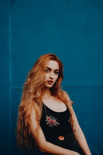 Woman Wearing Black Tank Top Beside Blue Painted Wall · Free Stock Photo