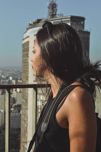 Woman Wearing Black Tank Top Standing Near Gray Concrete Building