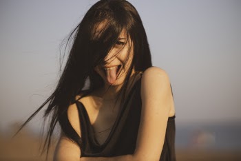 Woman Wearing Black Tank Top Sticking Her Tongue Out