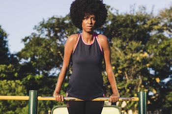 Woman Wearing Black Tank Top With Pink Trim on Yellow Metal Handrail