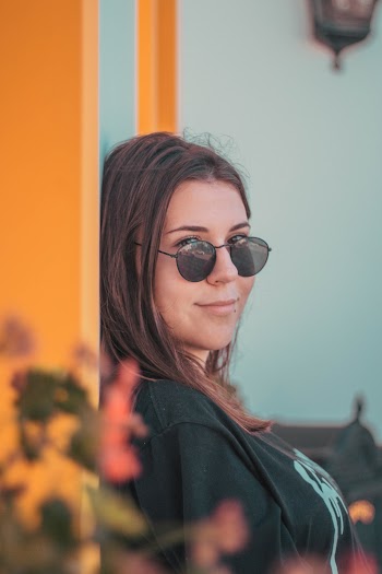 Woman Wearing Black Top and Black Round Sunglasses Looking at Side