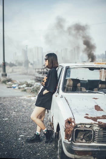 Woman Wearing Black Top Leaning on White Car