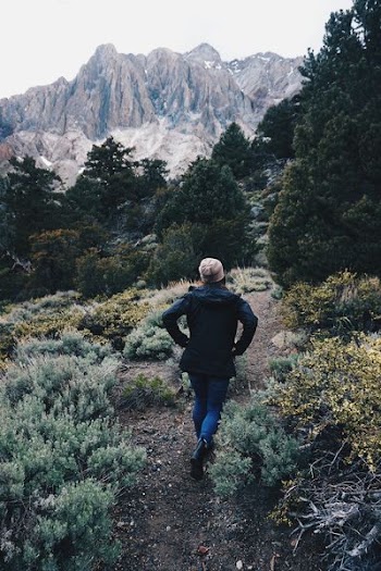 woman wearing black top walking on soil