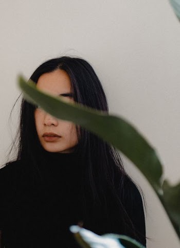 woman wearing black turtleneck long-sleeved shirt near white wall