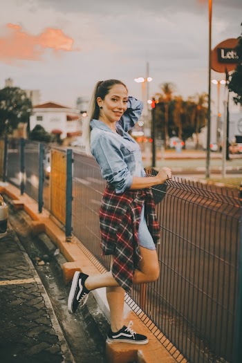 Woman Wearing Black Vans Shoes Standing Besides Steel Fence