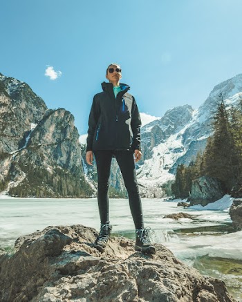 Woman Wearing Black While Standing on Rock