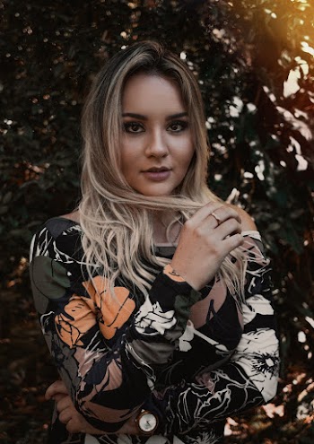Woman Wearing Black, White, and Orange Long-sleeved Shirt Holding Her Blonde Hair