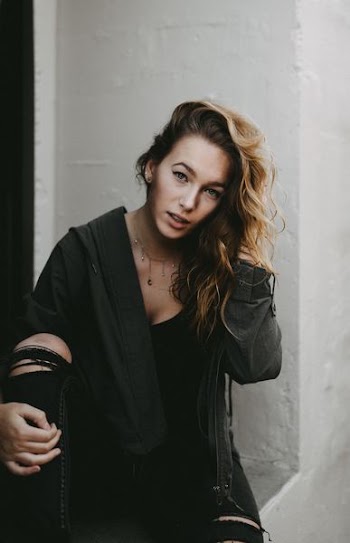 woman wearing black zip-up hoodie jacket and distressed black jeans