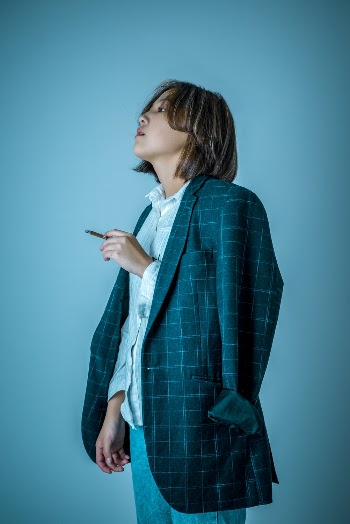 Woman Wearing Blazer While Standing Against Blue Background
