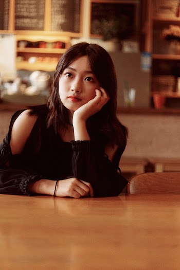 Woman Wearing Blouse Sitting Beside Table