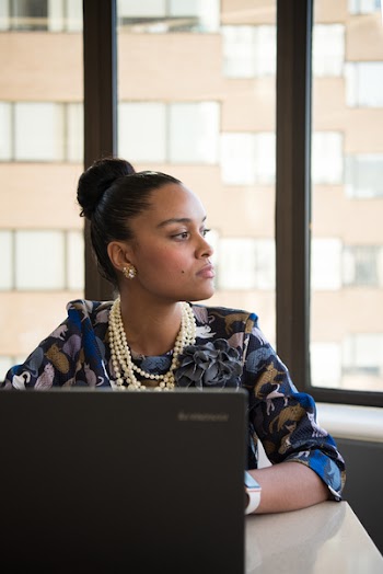 Woman Wearing Blue and Brown Floral Elbow-sleeved Dress Facing Black Lenovo Laptop Near Glass Window