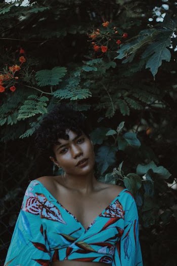 woman wearing blue and red crop-top making post near plant
