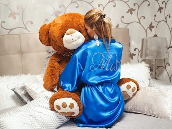 Woman Wearing Blue Bathrobe While Hugging Brown Bear Plush Toy