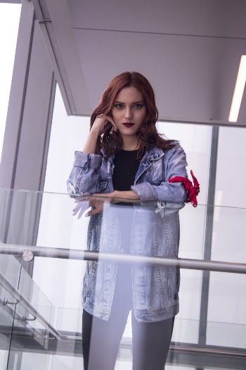 Woman Wearing Blue Denim Jacket Leaning On Clear Glass